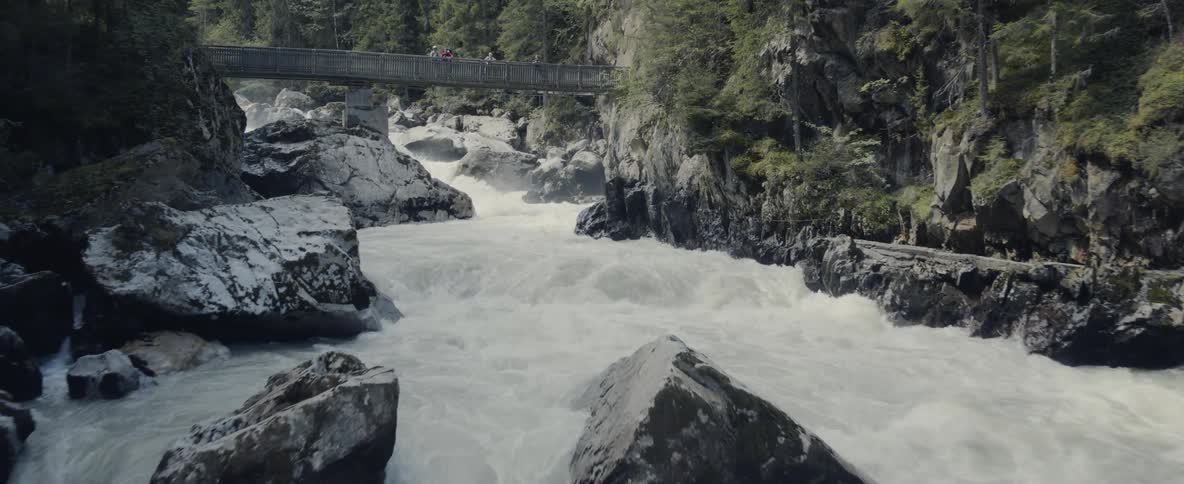 Rapids flow under foot bridge