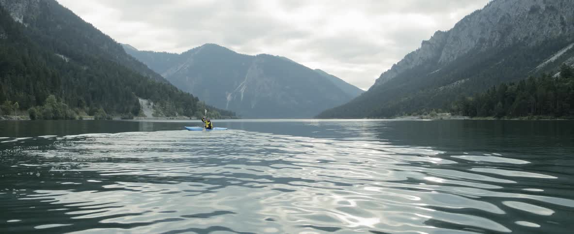 Kayaking in relaxed waters between mountains