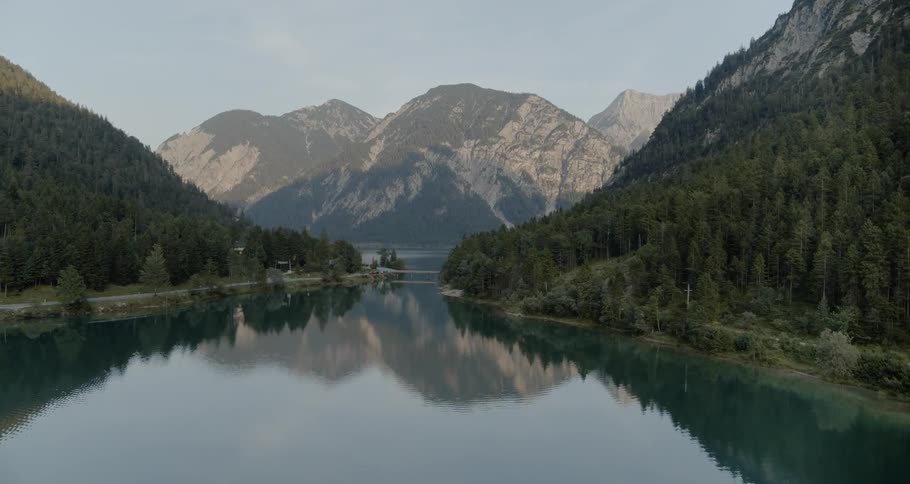 Lake bordered by forest and mountains