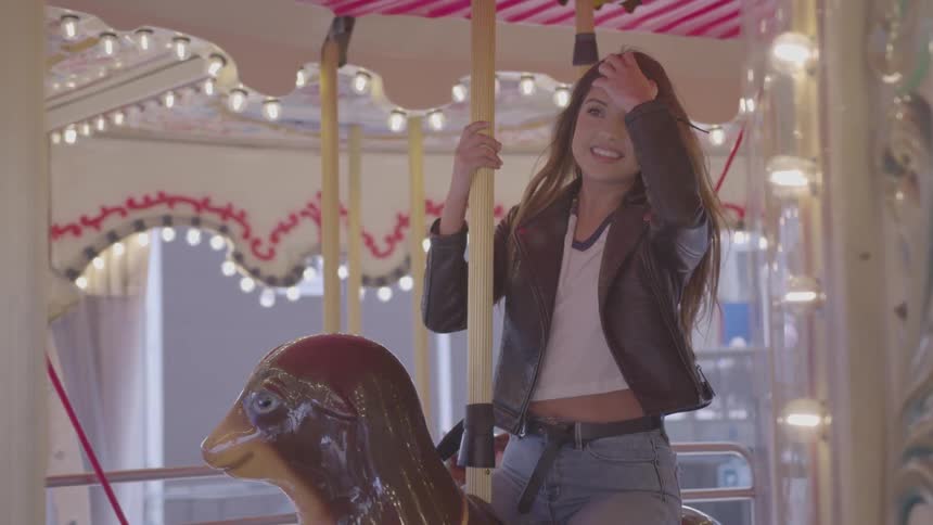 A female riding on a carousel