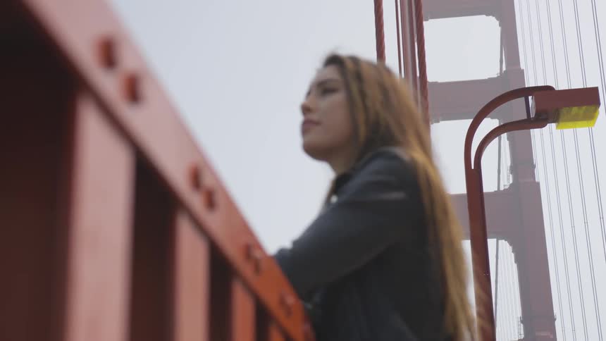 A woman sightseeing while standing on a suspension bridge