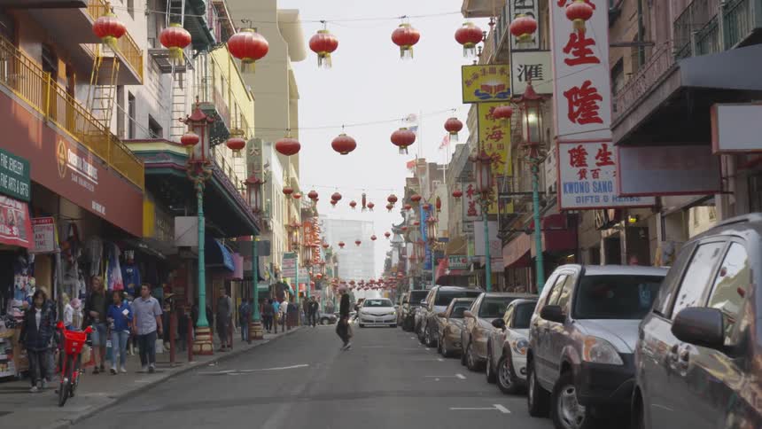 A man walks across a crowded street in an ethnic neighborhood