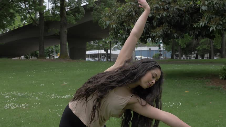 A woman bends over to her side in a dance pose