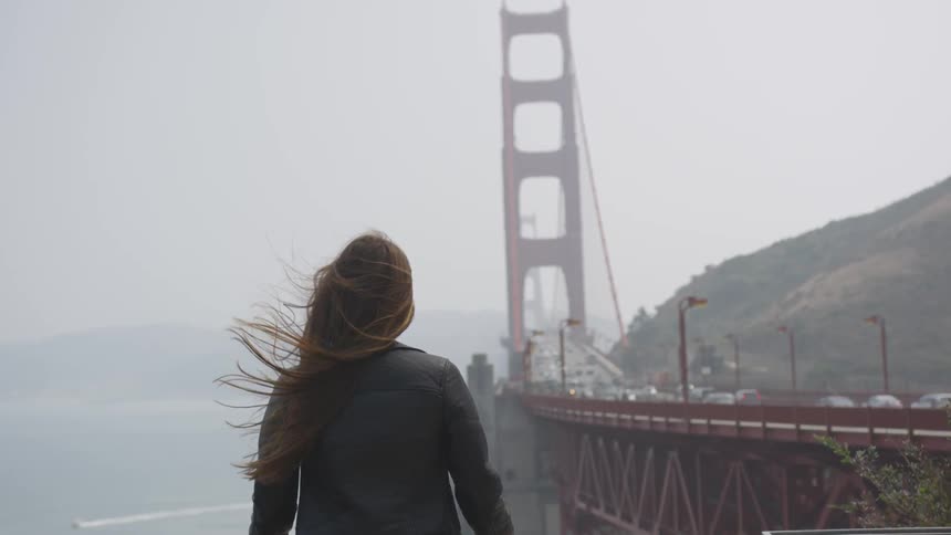 A woman is looking outdoors at the horizon