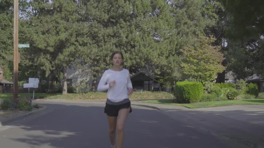 Woman jogs down the street in the morning