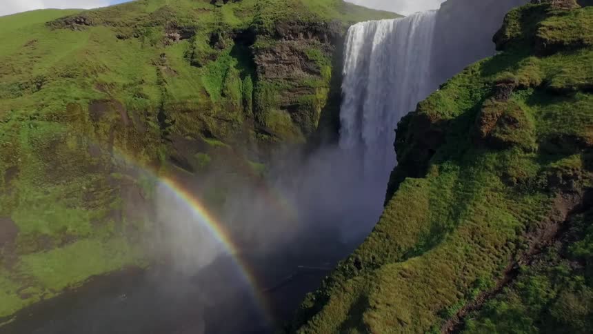 View of cliff and a waterfall making a rainbow on a sunny day