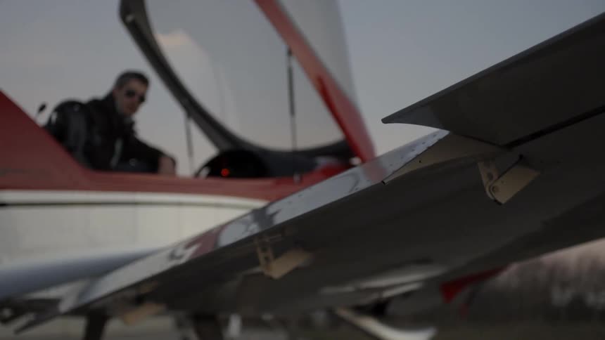 Pilot sits in his plane and adjusts a wing piece