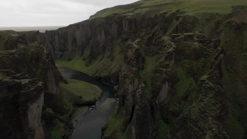 A winding river between moss covered mountains