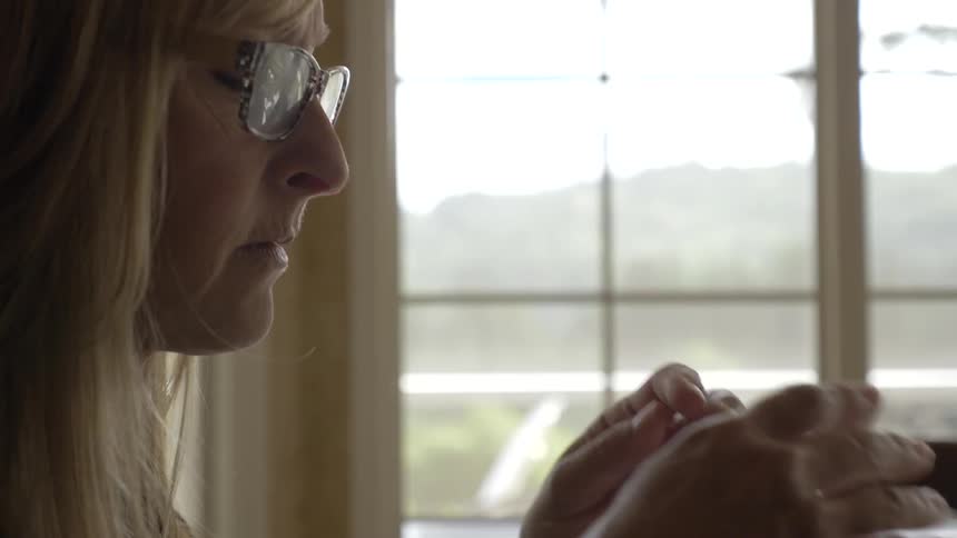 Woman gets frustrated and takes off glasses and puts head in her hands