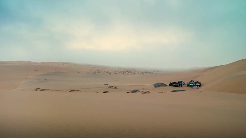 Multiple suv's sit parked in the middle of the desert