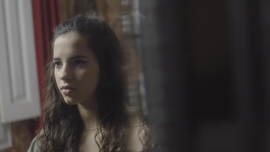 A young woman gazing at something before she spins around and smiles