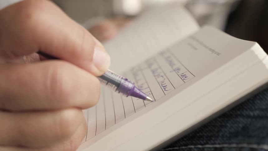 A person writes in a notebook