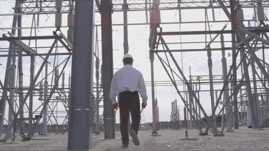 A worker walking around electrical towers