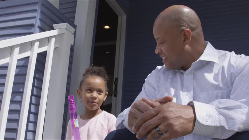 Man and girl sit talking on porch steps