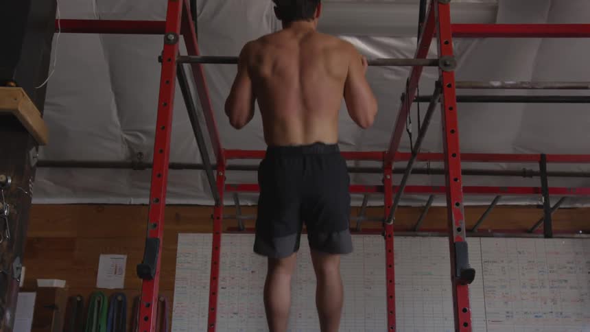 Man does pull ups on metal scaffolding