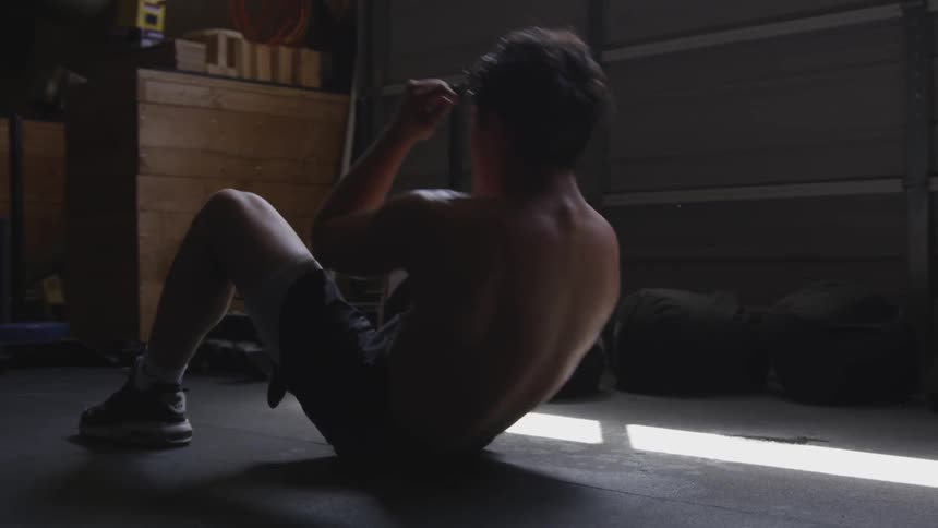 Man does sit ups in gym