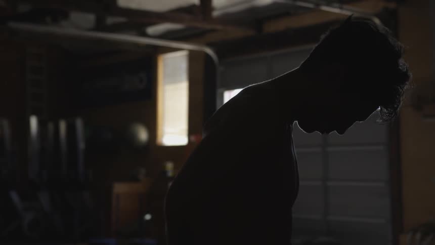 Man stands in dark garage gym