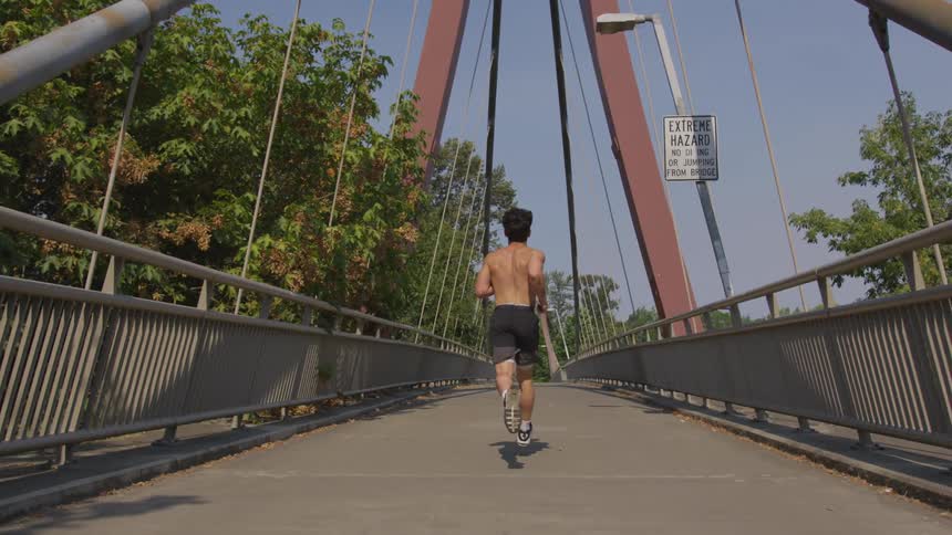 A man runs on a bridge path