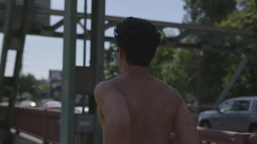 A man is running on a path next to a bridge