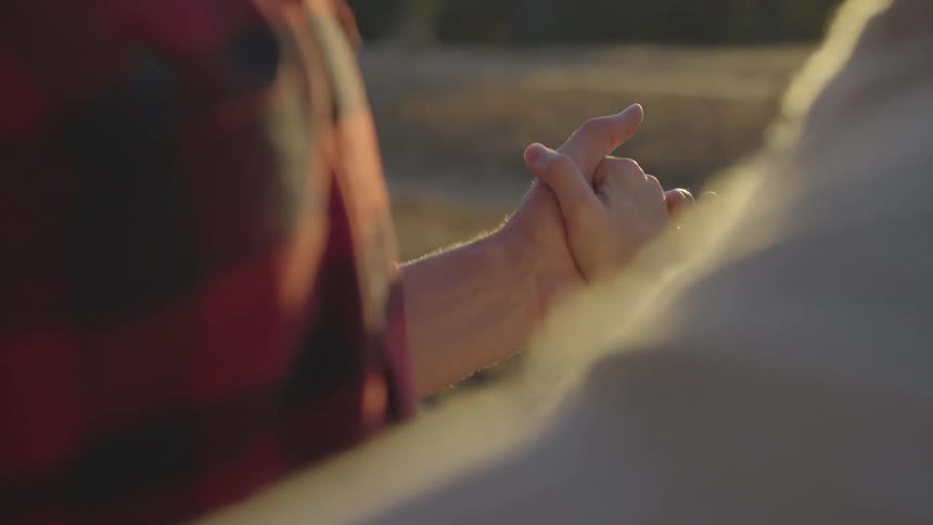 A couple slow dances outside at sunset