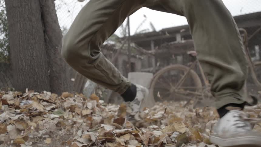 Man break dancing on dry leaves