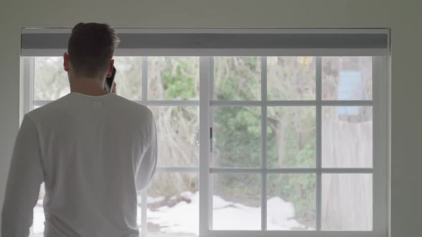 A man talks on the phone as he paces and gesticulates with his hands