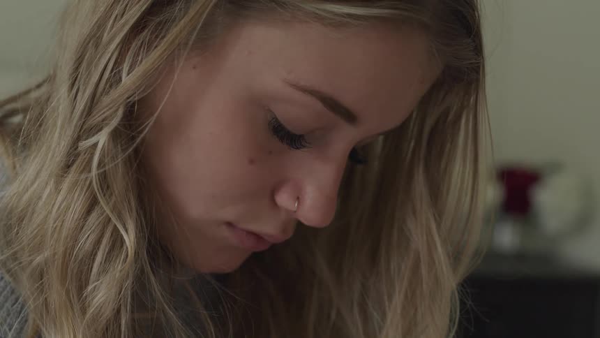 A woman with a nose piercing rests her eyes