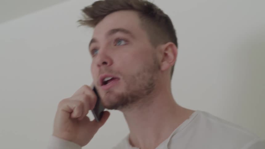 A man yelling into a cell phone and angrily reacting