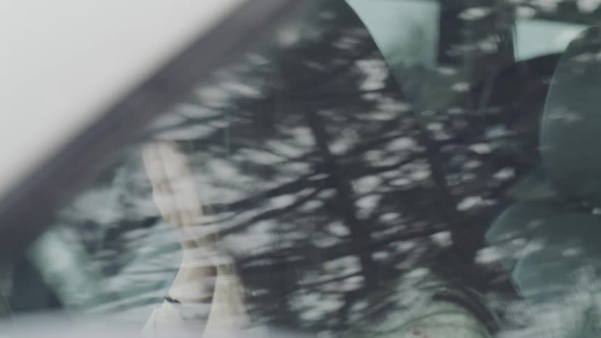 Asian woman cries in the car during daylight