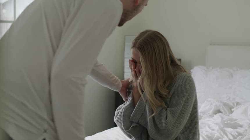 A man talks to a woman in a bedroom