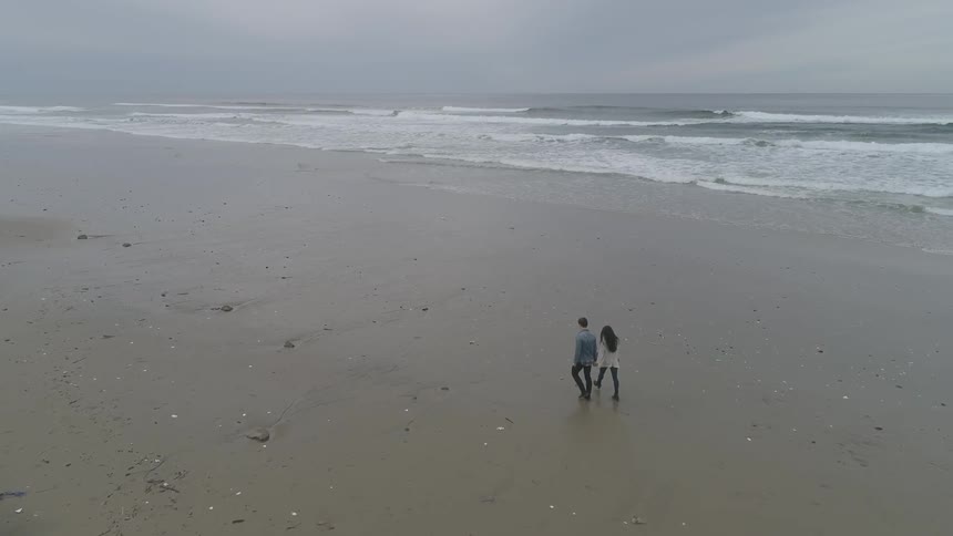 Couple walks along beach