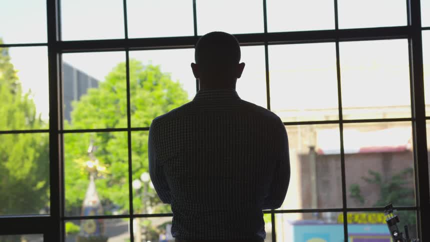 A man is staring out a window