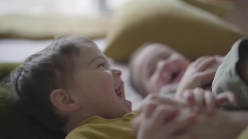 A person tickles two small children
