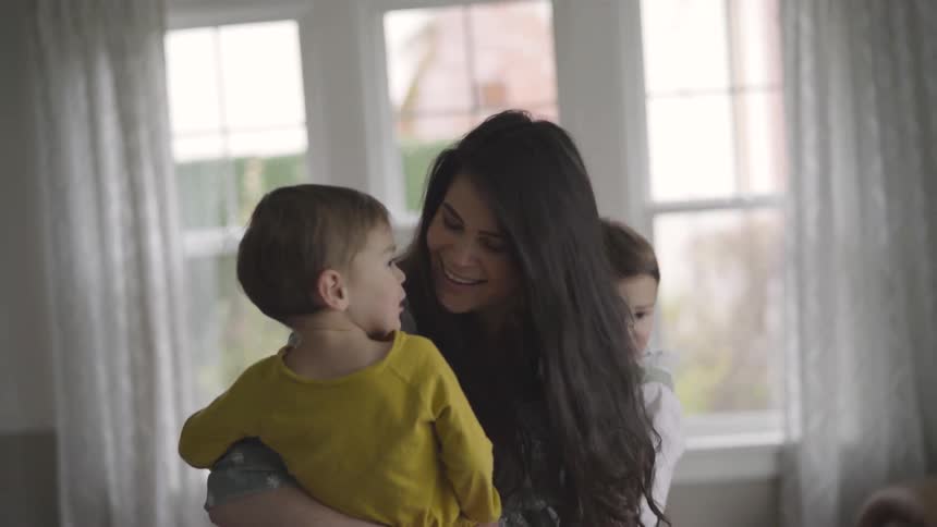 Woman holds two toddlers