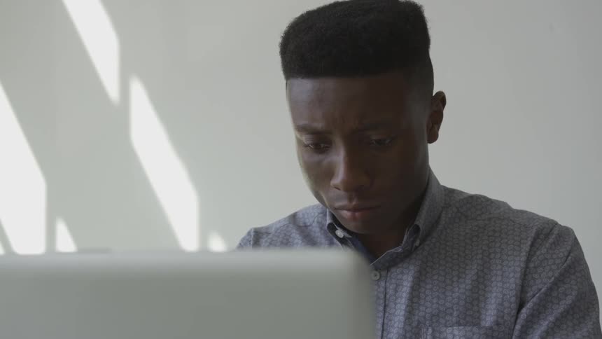Black man sitting at a computer