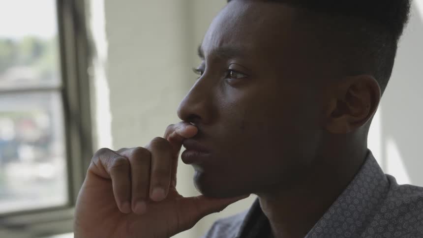 A young man stares into the distance