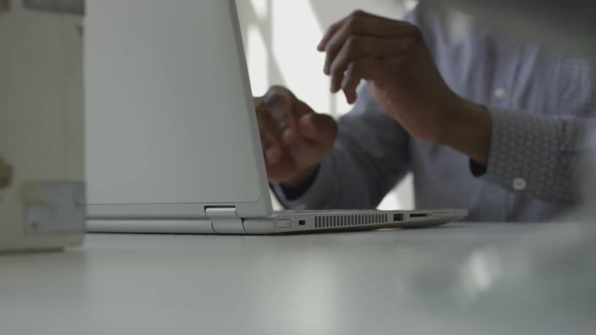 A black man using a laptop during the day