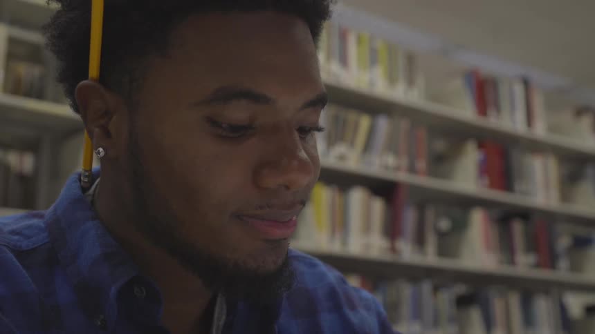 A young man studies in the library