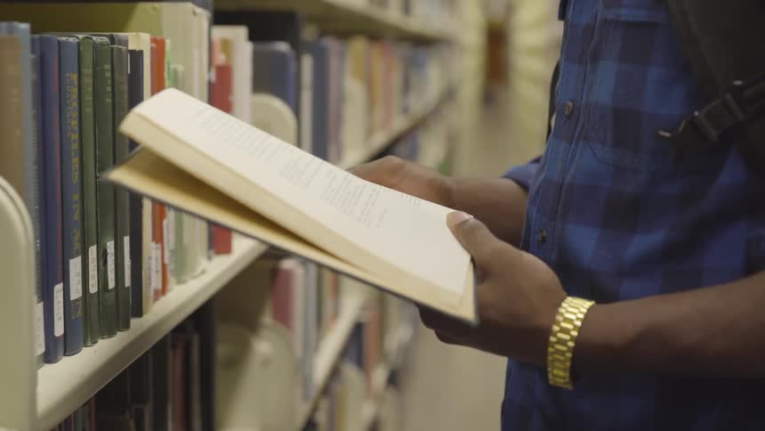 A man reading a book in a library