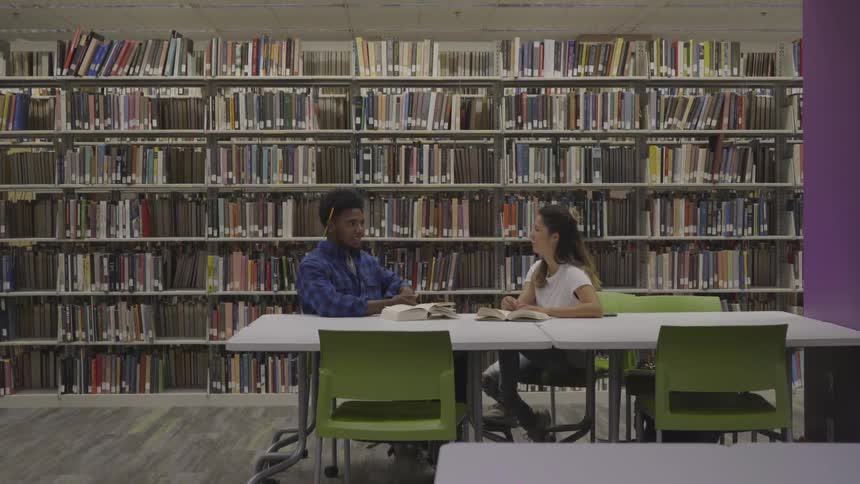 Two people speak in the library