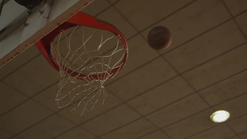 A basketball falling through a basketball hoop