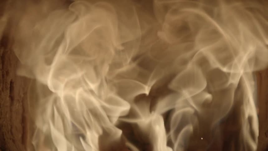 White smoke billows from burning logs