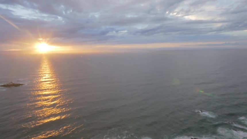 Aerial view of cliff and ocean at sunset