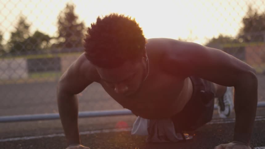 A man does push ups on a track