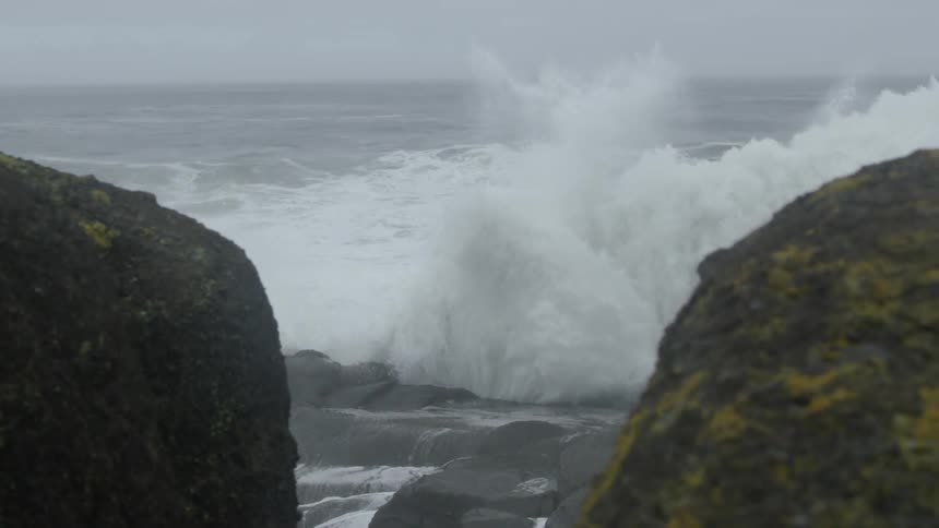 Large ocean waves crash over a beach