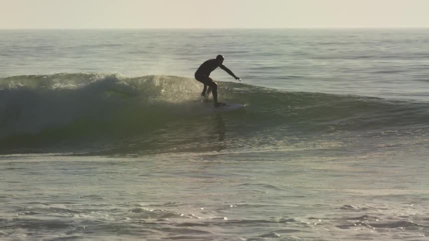 Surfer riding waves on a hazy day