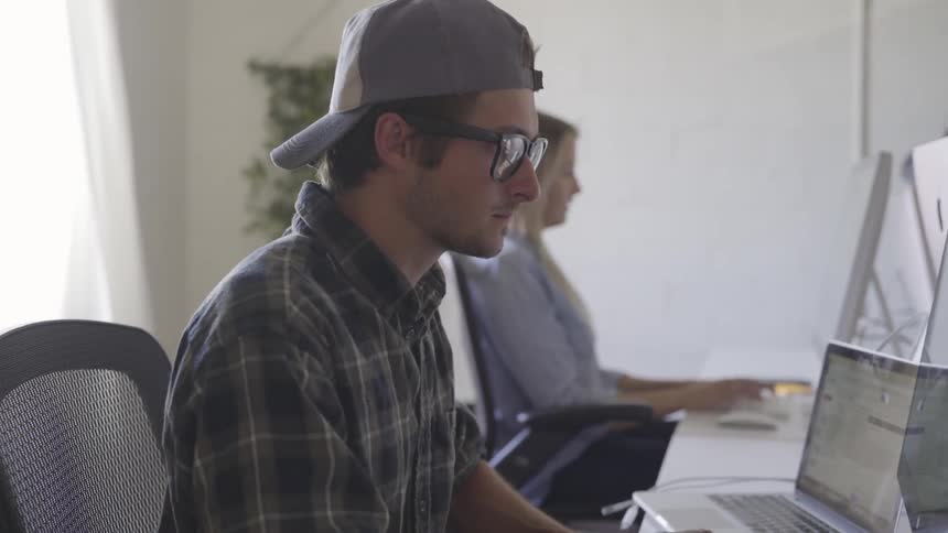 A man sitting typing on a computer