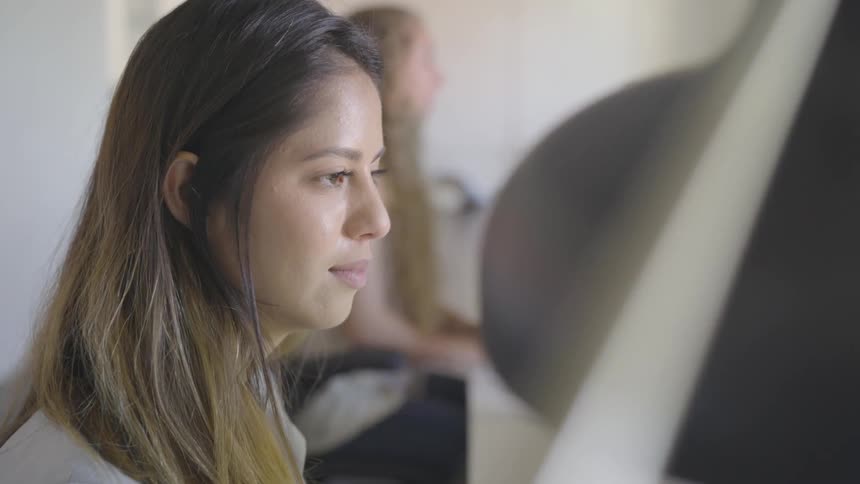 People working on computers at one large desk