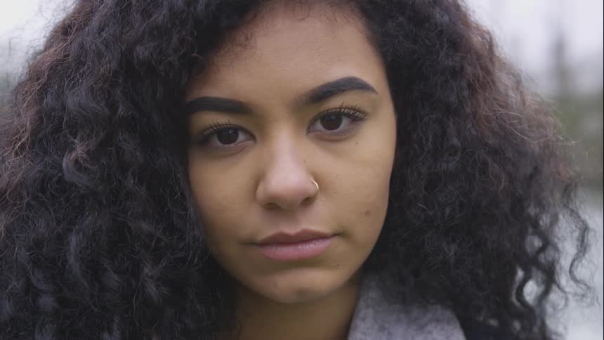 A woman looks into the camera