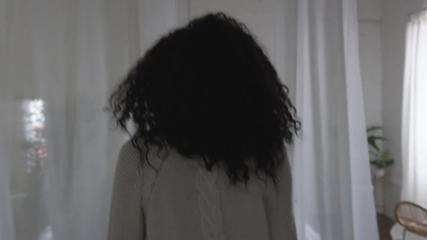 Lady walks between curtains